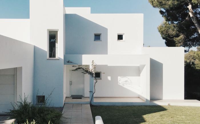 white concrete house near green tree during daytime by Fomstock courtesy of Unsplash.